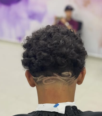 Corte masculino com fade e desenho artístico na lateral